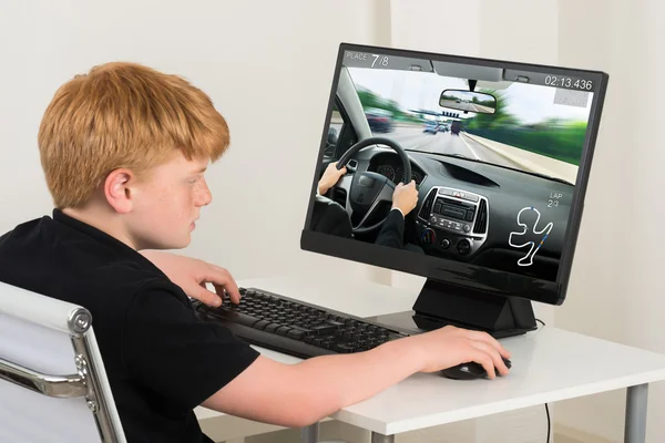 Niño jugando juego de coches en la computadora —  Fotos de Stock