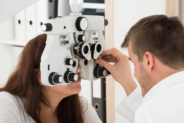 Manliga optiker undersöka kvinnliga patientens ögon — Stockfoto