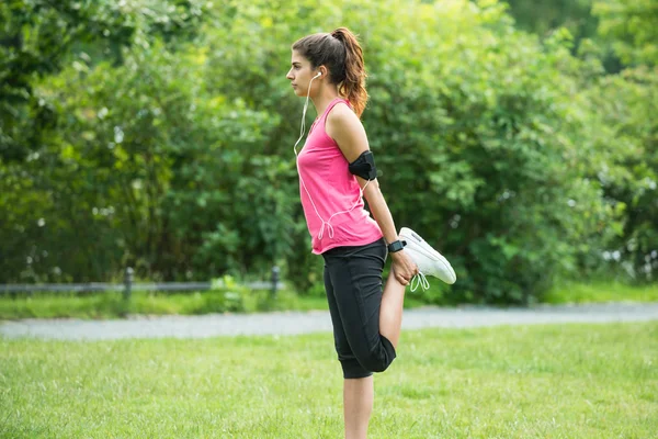 Молода жінка робить вправи в парку — стокове фото