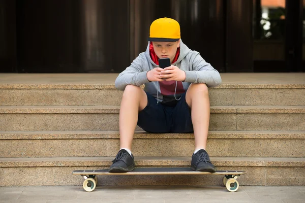 Boy Wearing Cap Looking At Cellphone — Stock Photo, Image