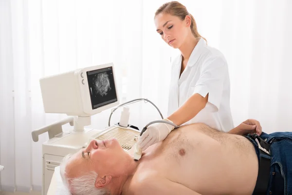 Человек получает ультразвуковое сканирование шеи доктором — стоковое фото