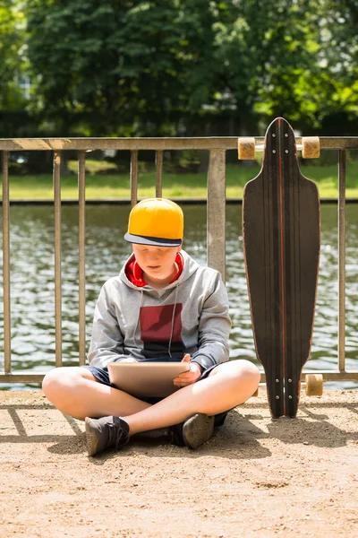 Pojke som bär locket med Digital tablett — Stockfoto