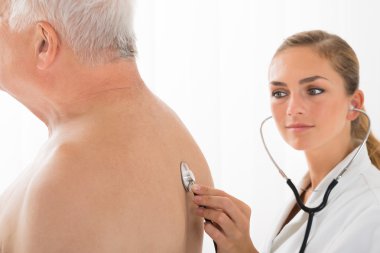 Doktor muayene hastanın stetoskop ile geri ver