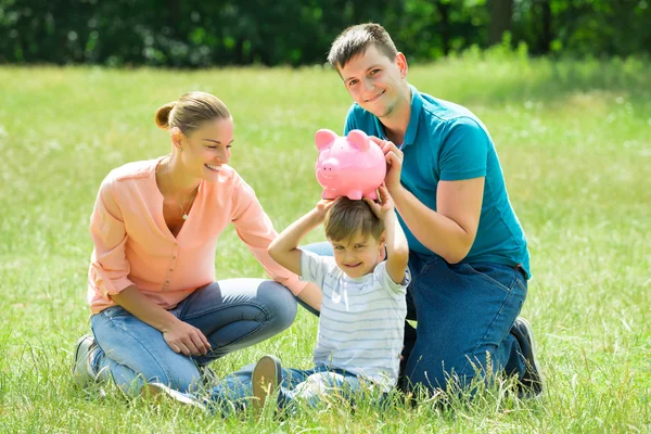 Parents avec leur fils tenant tirelire — Photo