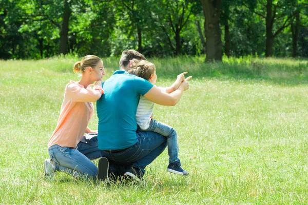 Famille regardant quelque chose dans le parc — Photo