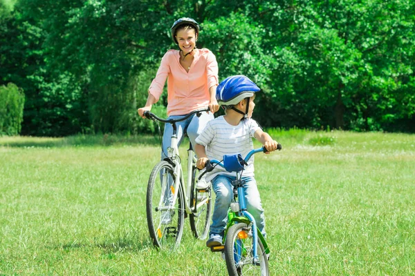 Mãe e filho estão de bicicleta no parque — Fotografia de Stock