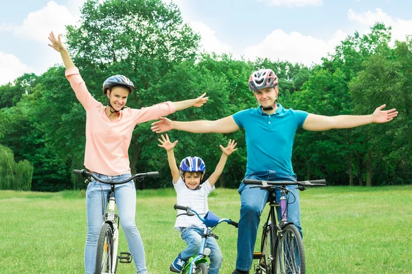 兴奋的家庭在公园里骑自行车 — 图库照片