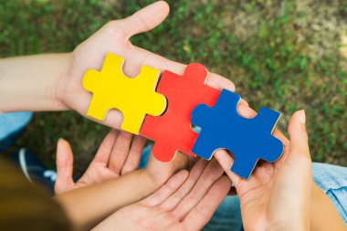 puzzle parçaları tutan eller