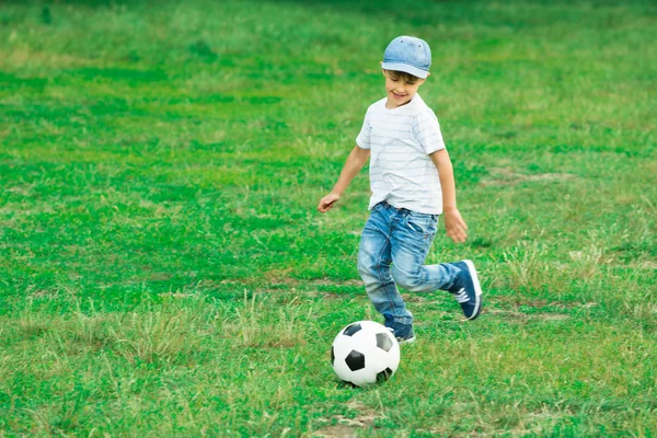 Çocuğun futbol topuyla oynuyor — Stok fotoğraf