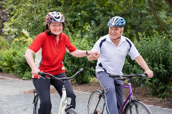 Couple tenant la main tout en faisant du vélo — Photo