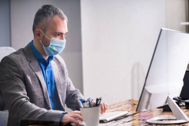 Ofisteki İş Çalışanları Tıbbi maske takıyor ve Sosyal Mesafe Protokolleri uyguluyor