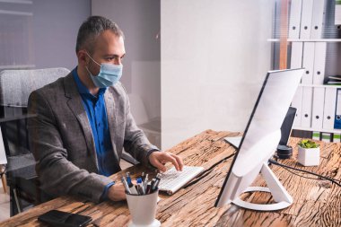 Ofisteki İş Çalışanları Tıbbi maske takıyor ve Sosyal Mesafe Protokolleri uyguluyor