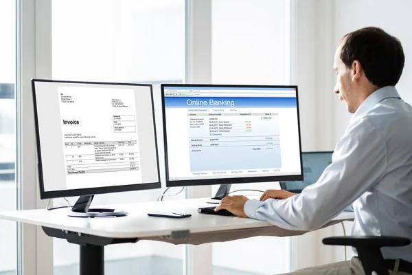 コンピュータでオンラインバンキングをしている間に請求書を見ている若いビジネスマン — ストック写真