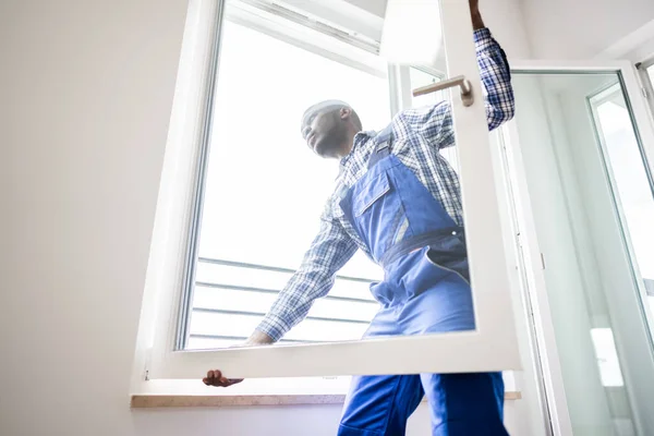 Jovem Reparador Africano Macacões Instalando Janela — Fotografia de Stock