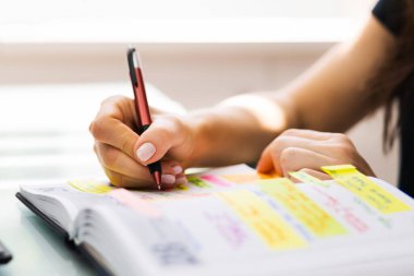 Ajanda ve Toplantı Zamanlaması İçin Takvim Defteri Günlüğü Kullanan Kadın