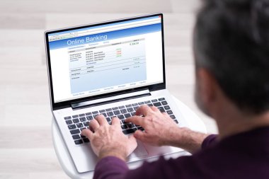 Yaşlı adam online bankayı para ödemek için kullanıyor.