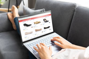 Kanepede dizüstü bilgisayar kullanan Kadın Çevrimiçi Ticaret Dükkanı