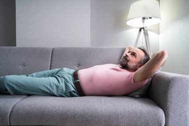 Oturma odasında koltukta dinlenen son sınıf öğrencisi.