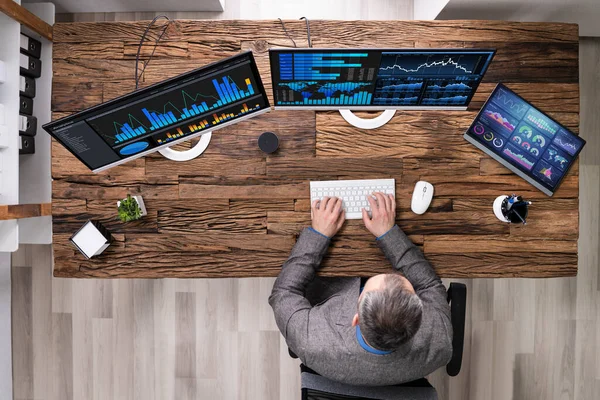 Analist Met Grafieken Meerdere Computerschermen Bij Balie — Stockfoto