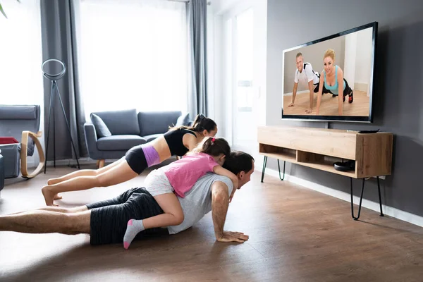 Rodzina Robi Ćwiczenia Fitness Podczas Oglądania Telewizji — Zdjęcie stockowe