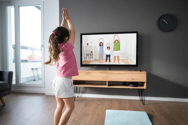 子供は自宅でオンラインテレビフィットネス運動を行う — ストック写真