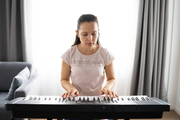 Woman Playing Music Keyboard Piano Instrument At Home