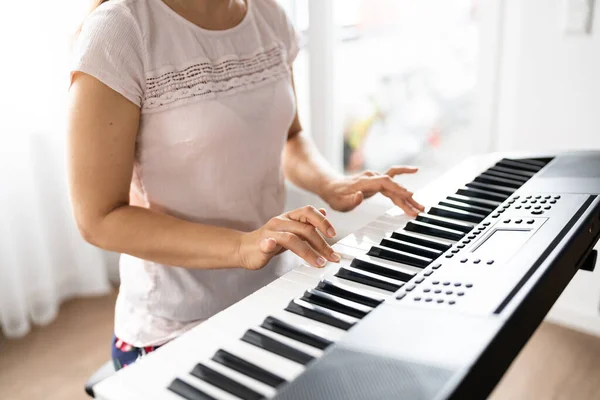 Woman Playing Music Keyboard Piano Instrument At Home