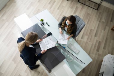 Otel resepsiyon masası tıbbi maske tarafından korunuyor.