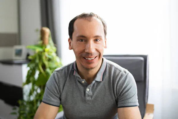 Portrait Of Smiling Man At Home In Video Conference