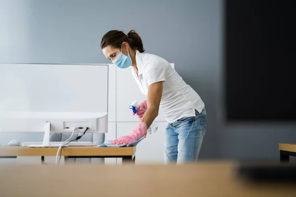 Office Desk Cleaning Service. Professional Janitor In Face Mask