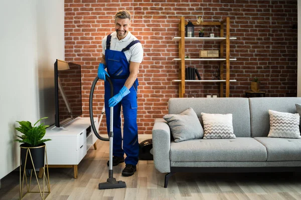 Człowiek Mundurze Vacuuming House Floor Sprzątanie Domu — Zdjęcie stockowe