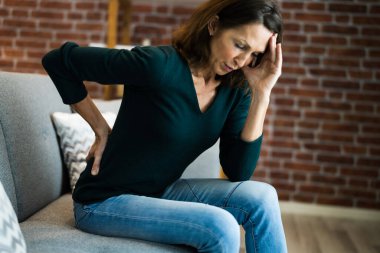 Sırtı ağrıyan ve acı çeken bir kadın. Kötü Duruş