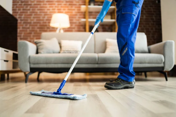 Home Floor Cleaning Service. Man Mopping Living Room