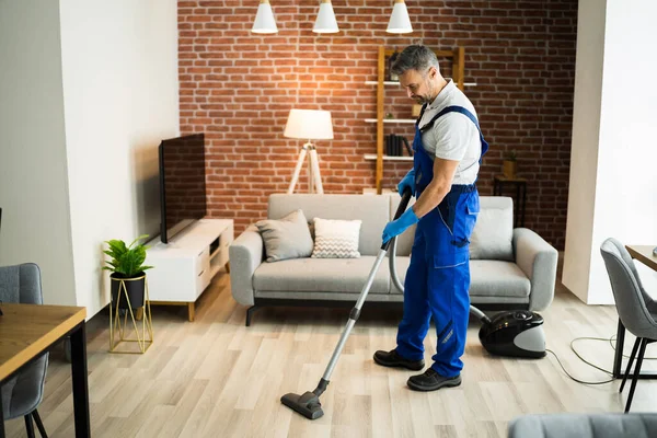 Człowiek Mundurze Vacuuming House Floor Sprzątanie Domu — Zdjęcie stockowe