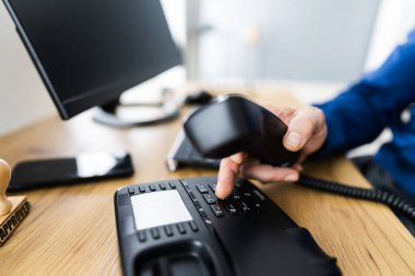 Ofiste telefon açmak için bir iş adamının el ile arama numarasının yakın çekimi.