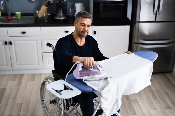 Gehandicapte Gehandicapte Man Een Rolstoel Strijkkleding — Stockfoto