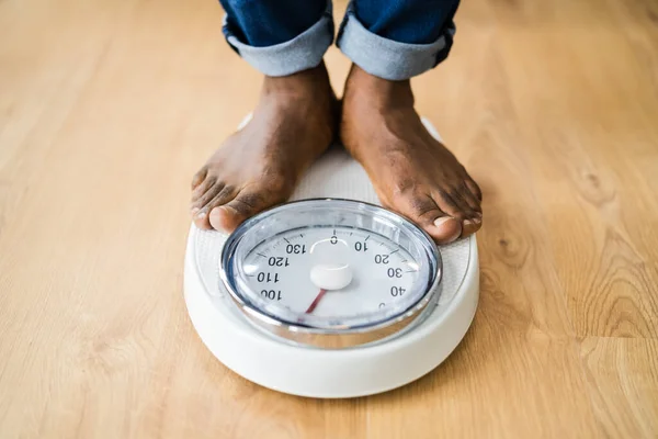 非洲人的脚站在体重秤上 低部分 — 图库照片