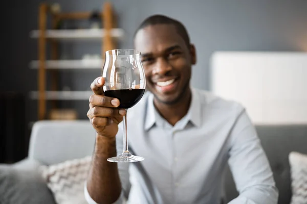 自宅でビデオ会議で赤ワインを飲む男 — ストック写真