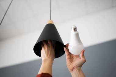 Kırık Ampulü LED olarak Değiştiren Kadın