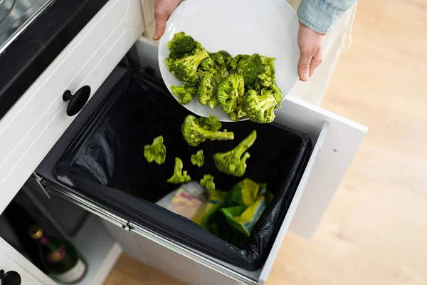 Throwing Away Leftover Food In Trash Or Garbage Dustbin
