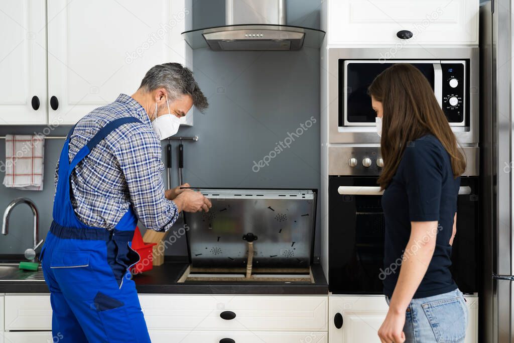 Induction Stove Repair And Maintenance By Electric Technician In Face Mask