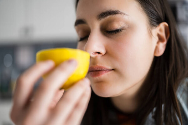 Woman Nose Sniffing Lemon Smell. Coronavirus Symptom
