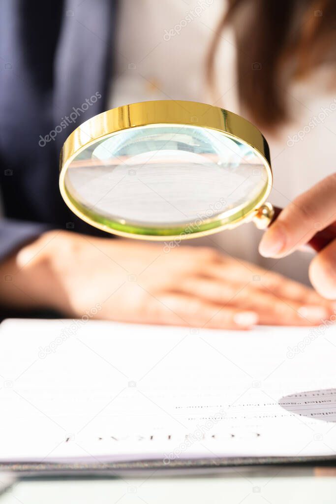 Auditor Hand Document Investigation With Magnifying Glass