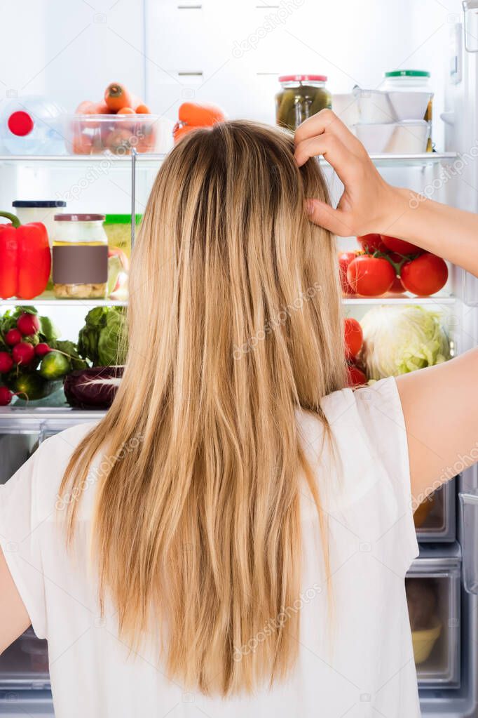 Hungry Woman Confused Near Open Refrigerator Or Fridge