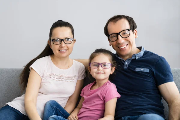 Family With Kid Daughter Wearing Glasses In Living Room
