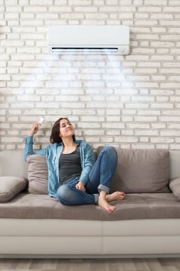 Odada Koşullandırıcı kullanan kadın. Oturma Odası Soğutma