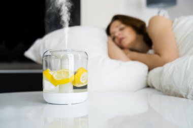 Home Air Humidifier Device In Bedroom Near Woman Sleeping clipart