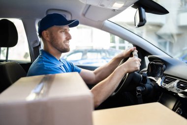 Arabadaki üniformalı teslimatçı.