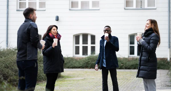 Social Distancing Employees Outside Drinking Coffee During Break