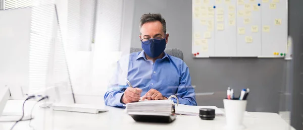 Elder Business Employee Working At Computer Wearing Facial Mask